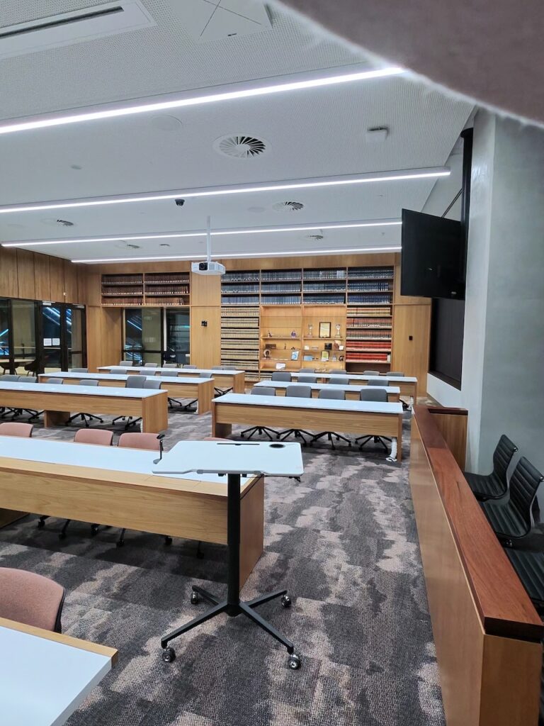 Law teaching room with timber desks and floor-to-ceiling shelves of law reports at ECU City Campus