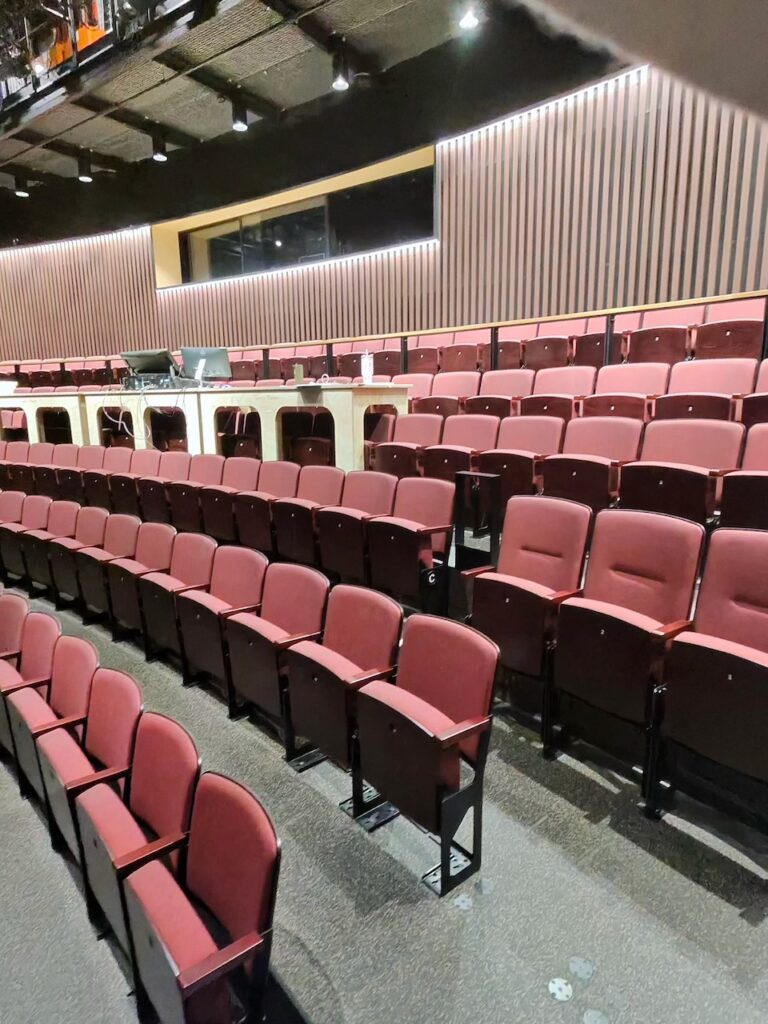 Rows of red raked theatre seats in a performance space at ECU City Campus